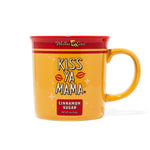 Gold Kiss Ya Mama mug with a pink rim and the white Kiss Ya Mama logo prominently displayed on the front.