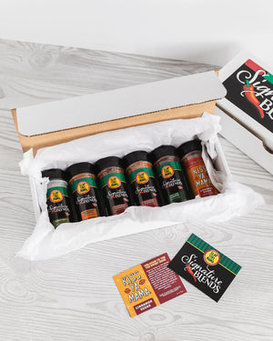 
                  
                    Load image into Gallery viewer, Open Signature Blend Kiss Ya Mama Combo Box filled with seasonings, displayed on a white counter, showcasing the variety of spices with the box in the background
                  
                