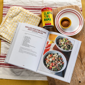 
                  
                    Load image into Gallery viewer, Open cookbook with recipe for grilled vegetables and zesty rice salad, featuring a can of Slap Ya Mama seasoning.
                  
                