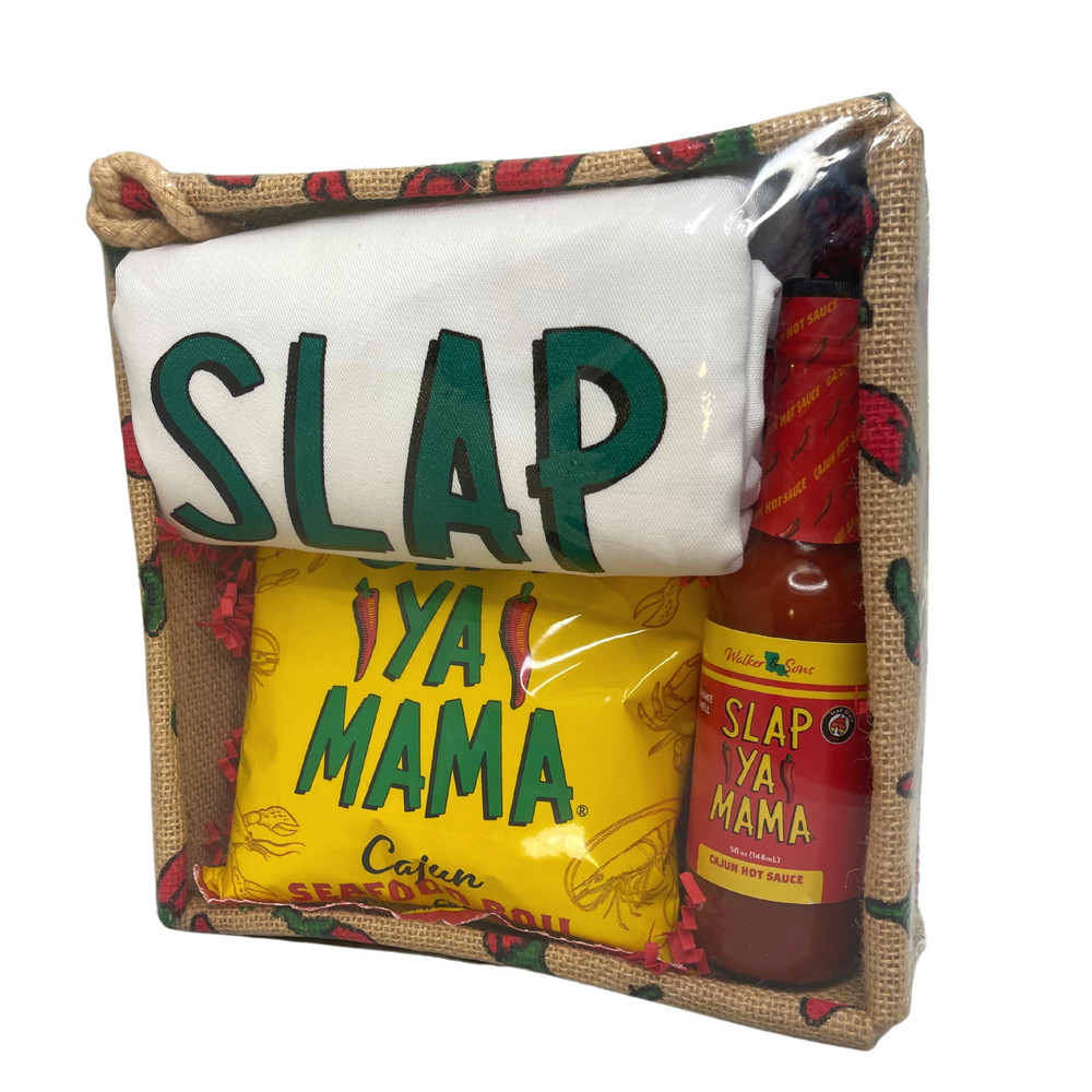 Slap Ya Mama White Cook's Apron, 1 lb bag of Slap Ya Mama Seafood Boil, and 5oz Cajun Hot Sauce, all wrapped in clear plastic and placed in a basket decorated with peppers.