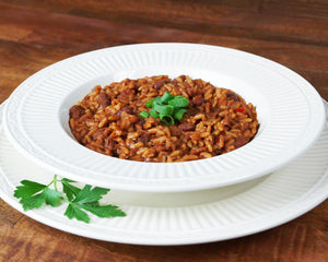 
                  
                    Load image into Gallery viewer, Bowl of red beans and rice with sausage, served in a white bowl and garnished with chopped green onions.
                  
                